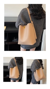 Vue détaillée du grand sac seau abricot montrant le cuir grainé et le fermoir doré