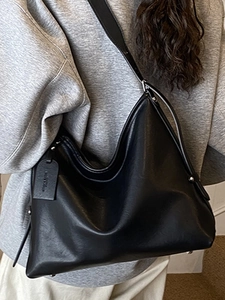 Minimalist black large capacity leather tote bag with stylish wide shoulder strap