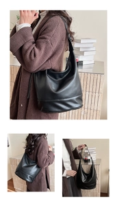 Close-up of a large black leather hobo bag with a soft crescent shape and pebbled texture