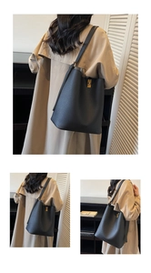 Détail du sac seau en cuir noir grainé avec un élégant fermoir rotatif doré carré
