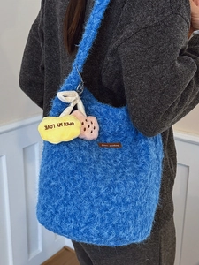 Blue fuzzy plush bucket bag with wide strap and colorful heart charm for women