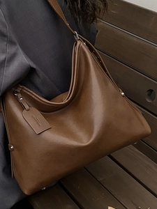 Minimalist deep brown leather hobo tote bag with rivet details and shoulder strap