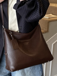 Minimalist large brown leather tote bag for women showing spacious commuter shoulder design