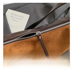 Detailed close-up of silver metal zipper and brown suede texture on a vintage hobo bag