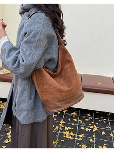 Detail view of brown suede and leather tote bag styled for autumn daily commuting