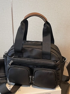 Minimalist black nylon handbag with multi-zipper pockets and crossbody strap for women