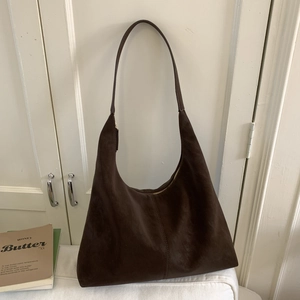 Detail of dark brown faux suede hobo bag showing fine stitching and top metal zipper closure