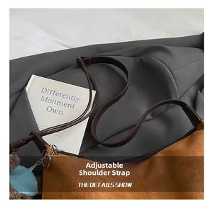 Detail of brown suede shoulder bag with adjustable strap and cute teddy bear charm