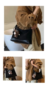 Detail of black patchwork shoulder bag with a cute brown plush bear charm accessory