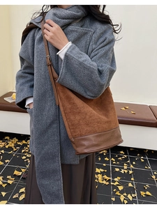 Detail view of brown vintage bucket bag featuring suede textures and smooth leather base