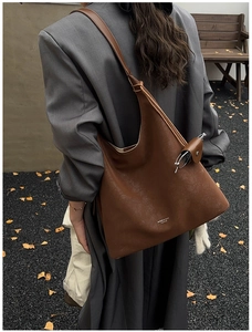 Detail view of large dark brown leather tote bag with functional sunglasses holder strap