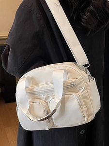 Minimalist white nylon crossbody bag with multi-pocket design and wide canvas shoulder strap