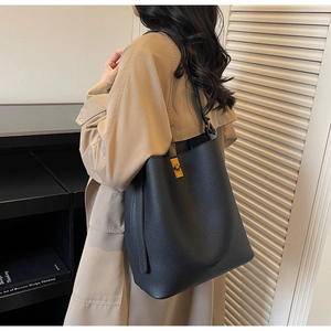 Détail du sac seau en cuir gris foncé avec fermoir rotatif doré de haute qualité