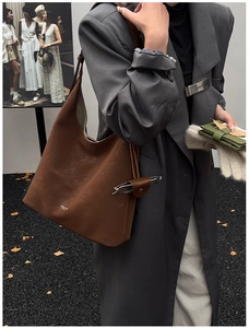 Detail view of large brown tote bag with innovative integrated eyeglass pouch and leather texture