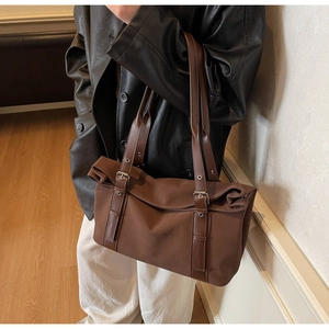 Vue détaillée du grand sac fourre-tout marron foncé avec boucles argentées et sangles vintage