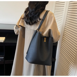 Détail d'un grand sac cabas en cuir gris grainé avec un fermoir rotatif doré chic