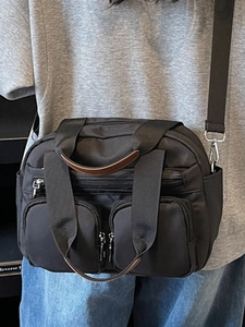 Versatile black multi-pocket shoulder bag with brown leather trim and silver zippers