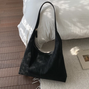 Detailed view of matte black suede hobo bag featuring wide strap and stitching detail