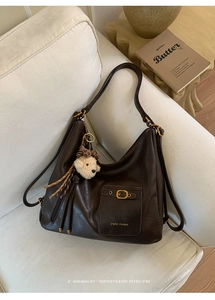 Detail of retro dark brown tote bag with leather texture and bear charm