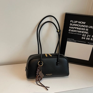 Detail of black litchi texture leather shoulder bag with gold hardware and brand logo