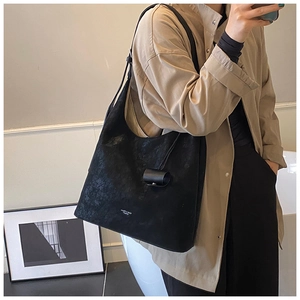 Detail shot of a black hobo tote bag with matte finish shown in a minimalist room