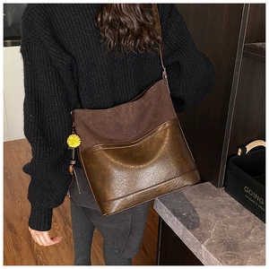 Detail of vintage brown two-texture hobo bag with matte suede and glossy wrinkled finish