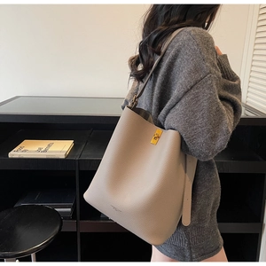 Détail du sac seau en cuir grainé kaki avec un fermoir rotatif rectangulaire doré