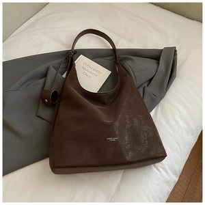 Close-up of brown tote bag with vintage cracked texture on a white cloth background