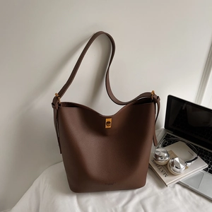 Détail du sac cabas en cuir grainé marron foncé avec fermoir doré et bandoulière intégrée