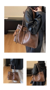 Detail view of a vintage dark brown leather tote bag with side drawstring and bear charm