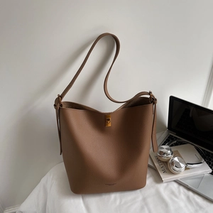 Détail du sac seau en cuir grainé marron foncé avec fermoir rotatif en métal doré
