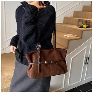 Detailed view of dark brown suede tote bag with stylish metal eyelet buckle decorations