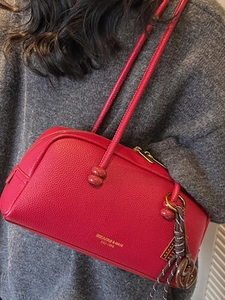 Chic red lychee leather pillow bag for women with golden logo and woven charm accessory