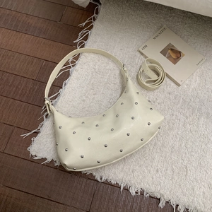 Schicke beige Ledertasche in Halbmondform mit silbernen Nieten und zwei Schultergurten