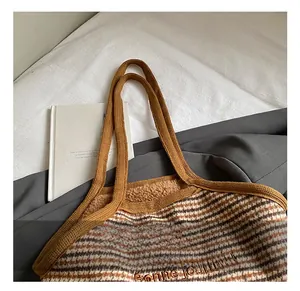 Detail of the cozy brown plaid wool tote bag with plush lining and embroidered greeting