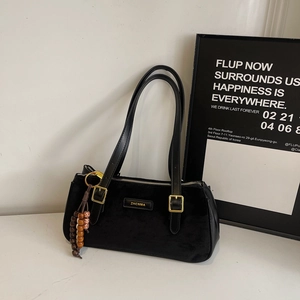 Détail d'un sac baguette en velours noir avec ferrures dorées et perles en bois rétro
