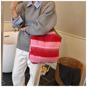 Detail of red striped fuzzy tote bag featuring Bonne journée embroidery and brown straps