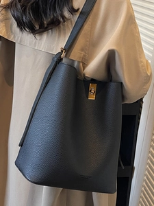 Sac seau minimaliste en cuir noir avec fermoir tournant en métal et large bandoulière
