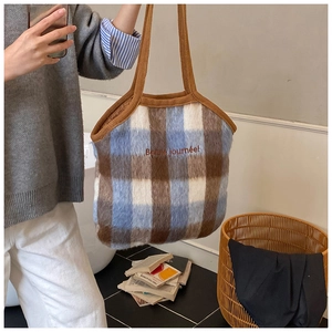 Detail of blue and brown plaid plush tote bag with Bonne journée embroidery and knit strap