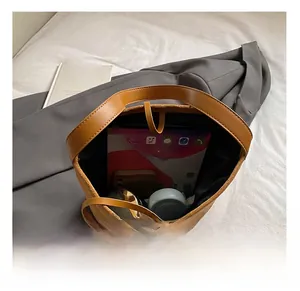 Vista dall'alto dello scomparto interno di una borsa in pelle marrone con accessori