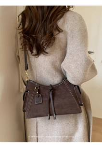 Detailansicht der dunkelbraunen Wildleder-Schultertasche mit Kontrastnähten und Metallteilen