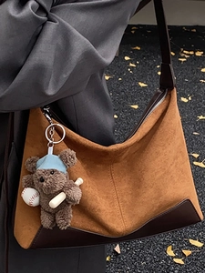 Vintage brown suede hobo bag with a cute baseball bear charm for autumn fashion style