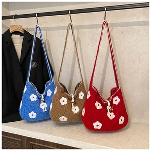 Detail of plush tote bags with floral embroidery and wooden toggle horn closures