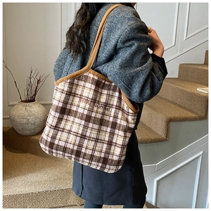 Detail of the textured plaid tote bag with French embroidery and brown corduroy handles
