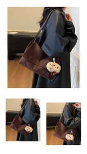 Brown suede shoulder bag with plush smiley charm shown from multiple angles