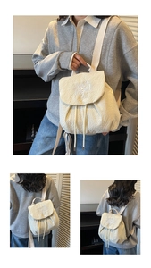 Detail of cream backpack showing pleated texture fabric and YOU BEAR! letter embroidery