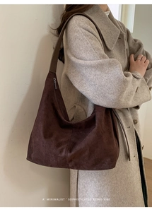 Vista laterale della borsa hobo in pelle scamosciata marrone scuro con forma morbida