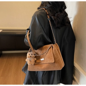 Detailansicht braune Wildledertasche mit Kettenriemen und Bärenanhänger-Accessoire