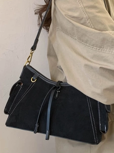 Schwarze Wildleder-Schultertasche mit weißen Kontrastnähten für stilvolle Pendlerinnen