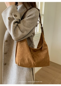 Dettaglio della borsa hobo in pelle scamosciata marrone con cuciture retrò e texture